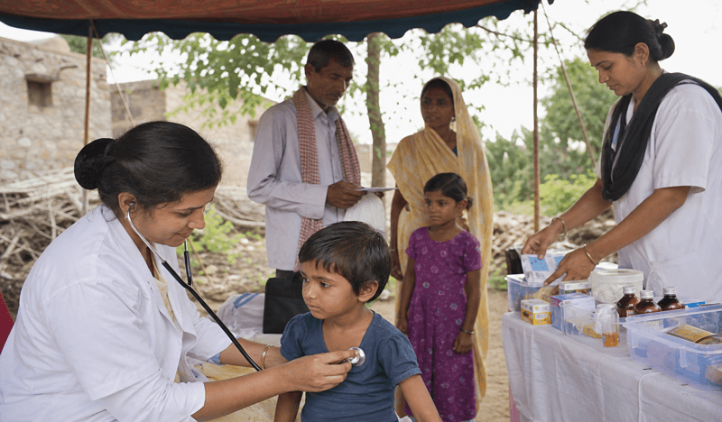 A healthcare worker checking a child at a local medical support camp.